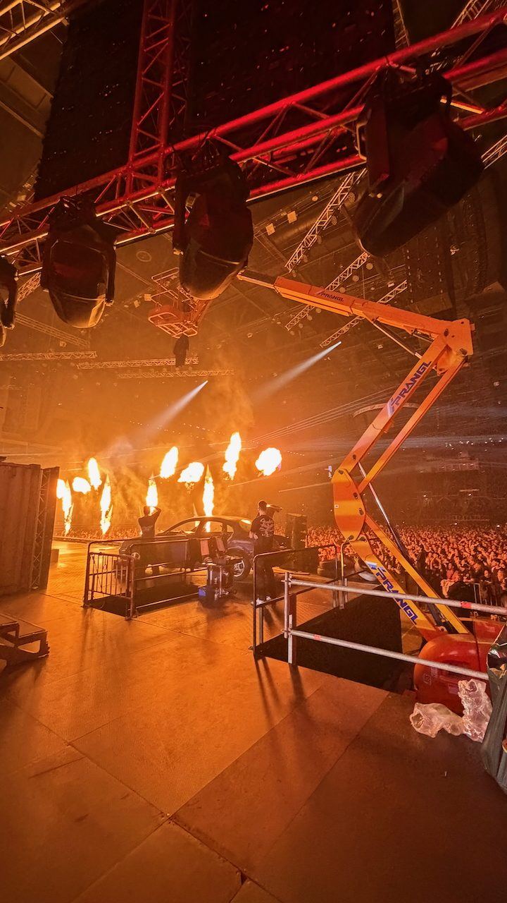 Pyro flames on stage seen from the wings of an arena show