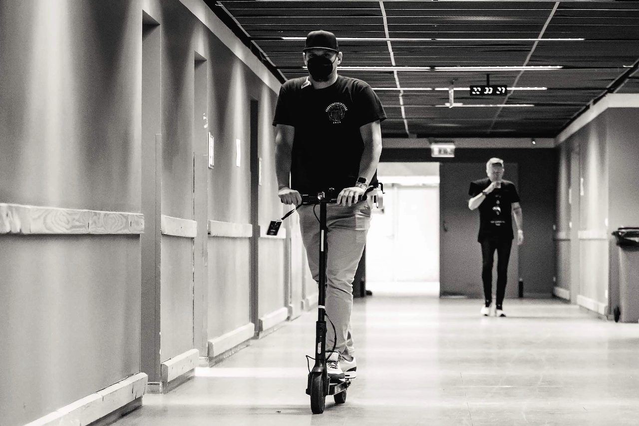Riding an e-scooter down a backstage corridor